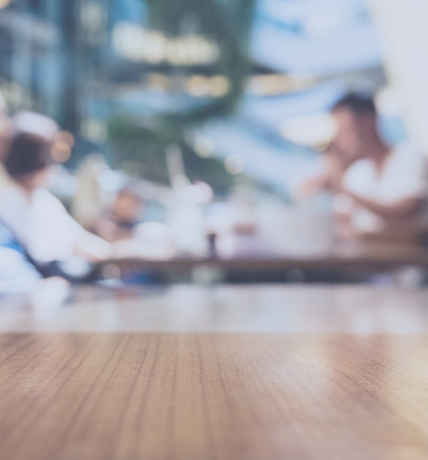 People out of focus in the background at table with computers.