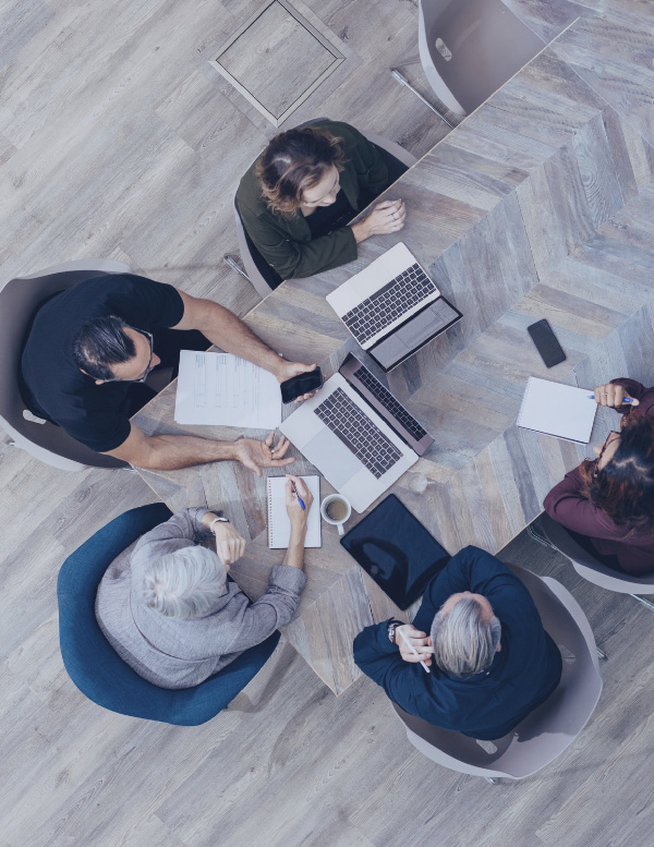 Overhead view of people gathered around a work table.